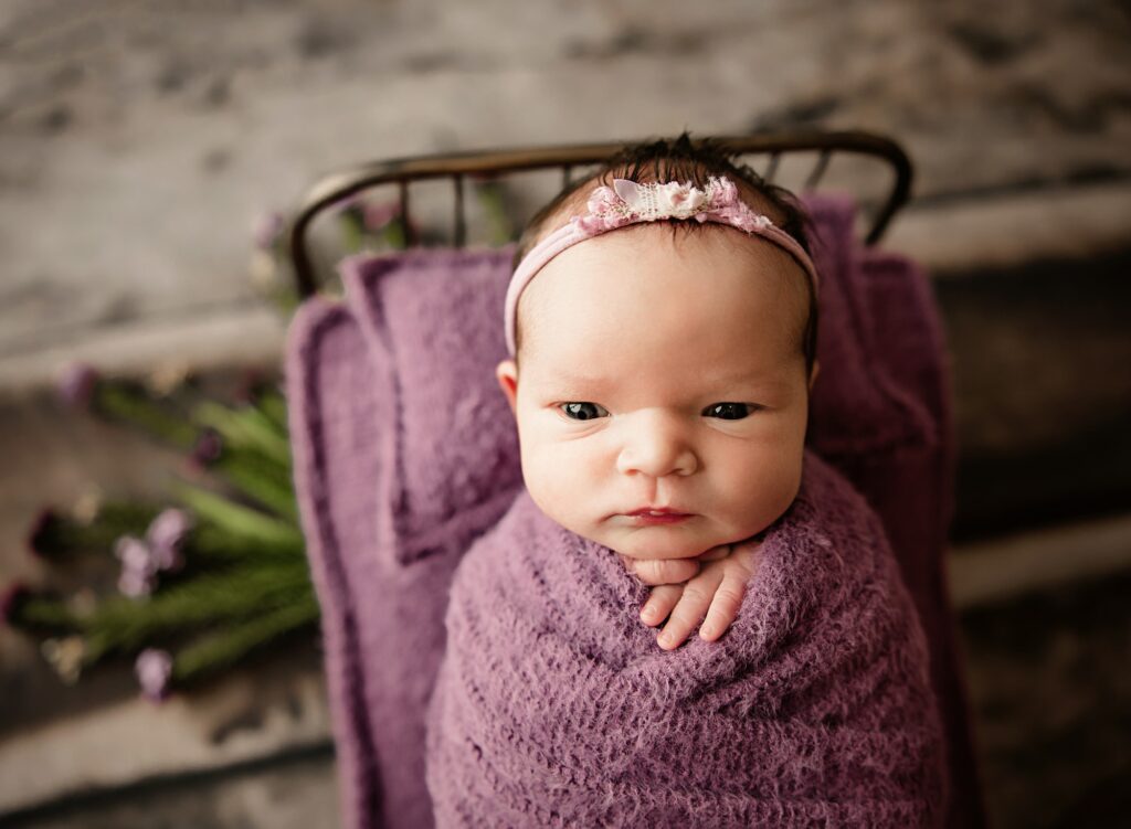 Sacramento newborn photographer posing baby in cozy blanket wrap