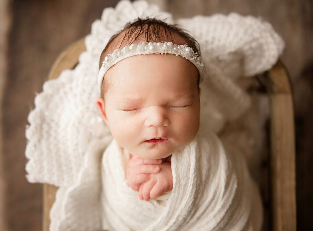 Sacramento newborn photographer posing baby in cozy blanket wrap