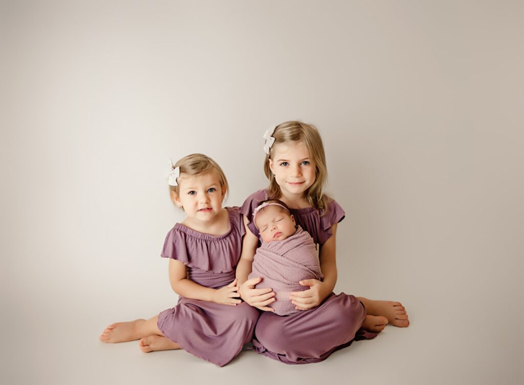 Professional newborn photographer gently supporting baby during photo session