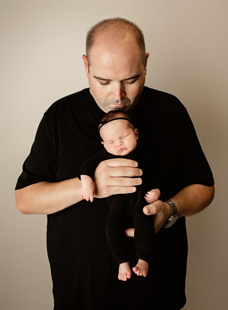 Family cuddles with newborn photographed in Sacramento studio