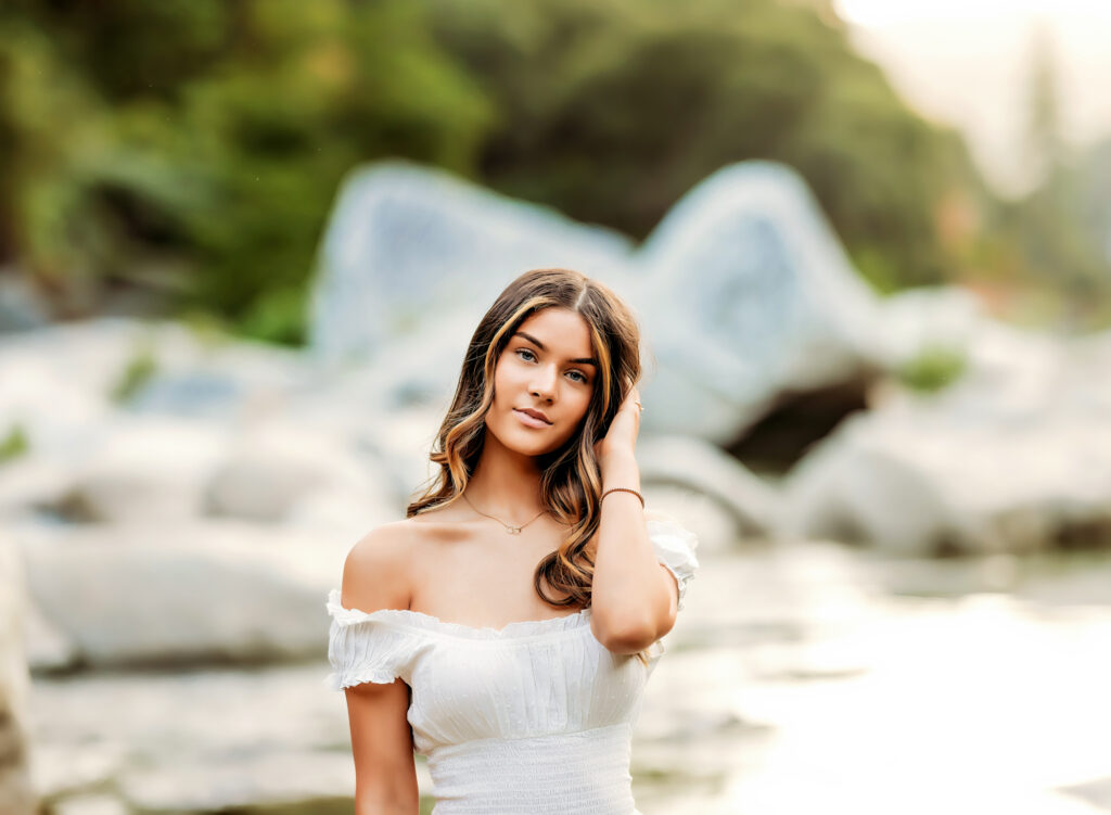 High school senior posing by the Sacramento River during sunset